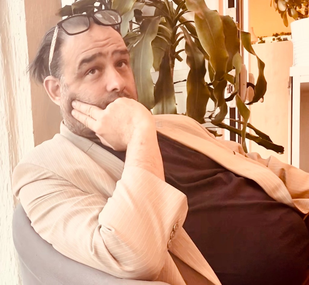 Porträtt på Kim som sitter i fåtölj och ser tankfull ut.